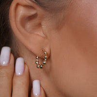 Load image into Gallery viewer, A Model Styling with 14k Gold Puffed Beaded Ball Hoop Earrings
