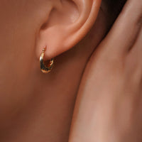 Load image into Gallery viewer, A model Styling with 14k Gold Small Puffy Twisted Hoop Earrings

